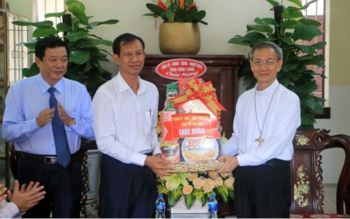 El secretario del Comité del Partido Comunista de Vietnam en la provincia de Vinh Long, Dang Van Chinh (izquierda), felicita al obispo Huynh Van Hai. (Fotografía: VNA)