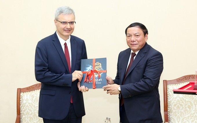 El ministro de Cultura, Deportes y Turismo de Vietnam, Nguyen Van Hung (D) recibe al embajador de Francia en Hanói, Nicolas Warnery.