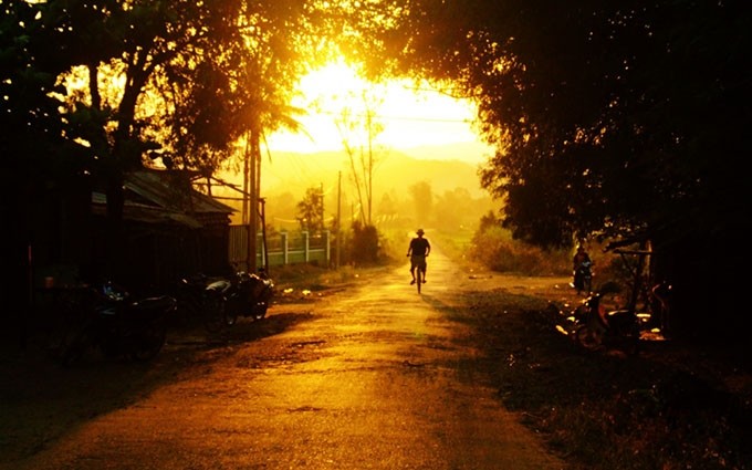 Un hombre monta en bicicleta bajo el sol del atardecer en el distrito de Dong Xuan. (Fotografía: vov.vn)