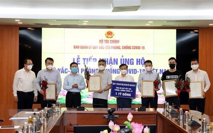 El Ministro de Finanzas de Vietnam, Ho Duc Phoc, y las organizaciones participantes en apoyo al Fondo Nacional de Vacunas contra el Covid-19 (Fuente: VNA)