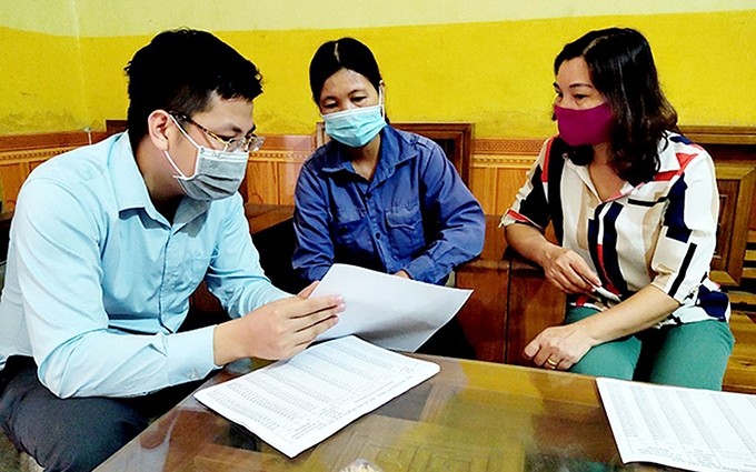 Un corredor del Seguro Social de la provincia norvietnamita de Yen Bai instruye a los empleados a instalar la aplicación VssID. (Fotografía: Hong Duyen)