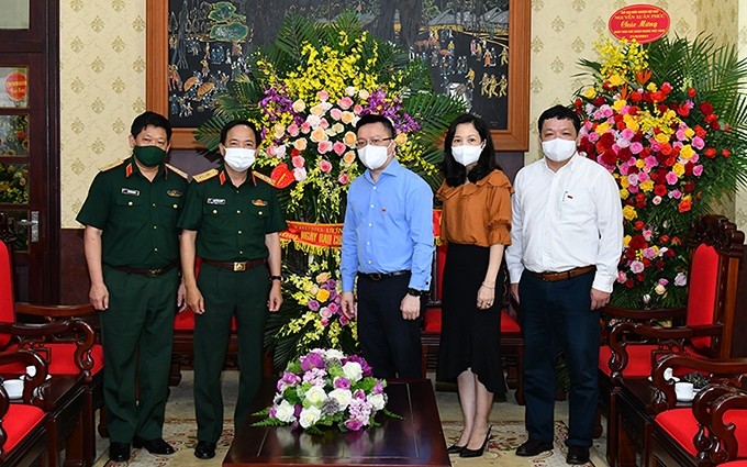 El general de división Trinh Van Quyet (segundo desde la izquierda) felicita por la fecha a representantes del periódico Nhan Dan. (Fotografía: Thuy Nguyen)