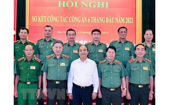 El presidente de Vietnam, Nguyen Xuan Phuc (camisa blanca), y el ministro de Seguridad Pública, general To Lam (segunda persona desde la izquieda, primera fila) en la cita. (Fotografía: VNA) 