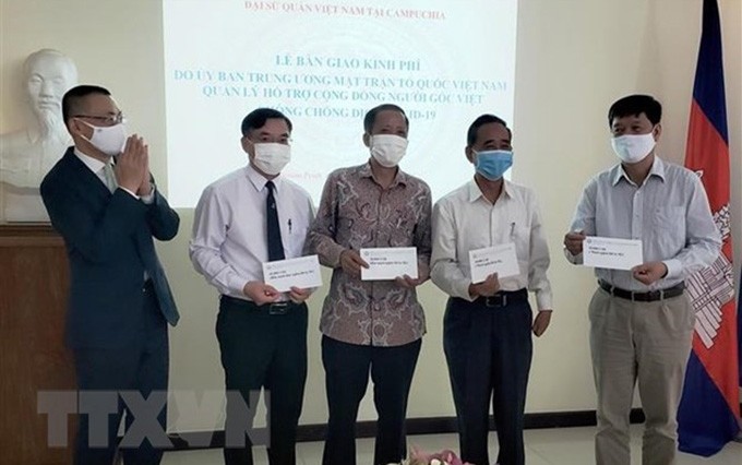 El embajador de Vietnam en Camboya, Vu Quang Minh, (a la izquierda), entrega donación a representantes de las misiones diplomáticas representativas y la Asociación Khmer-Vietnamita (Fuente: VNA)