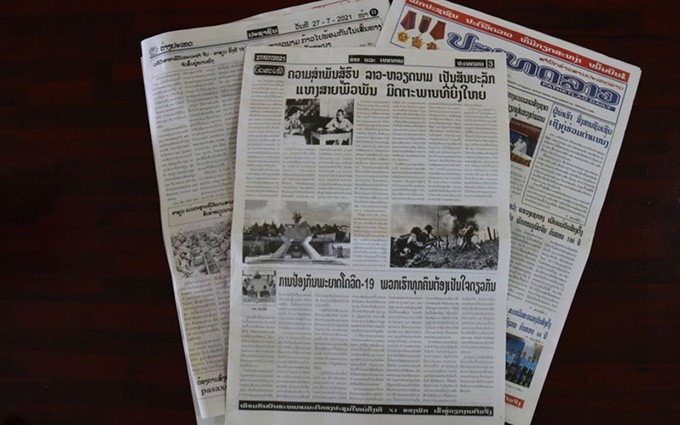 Periódicos laosianos publican artículos que destacan la Alianza Combativa Laos-Vietnam. (Fotografía: Nhan Dan)