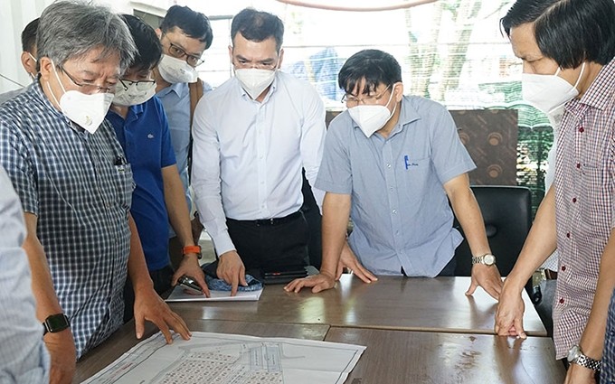 Expertos del Ministerio de Salud Pública revisan el plano del Centro de Reanimación Intensiva del Hospital de Campaña número 13 en Ciudad Ho Chi Minh. (Fotografía: Nhan Dan)