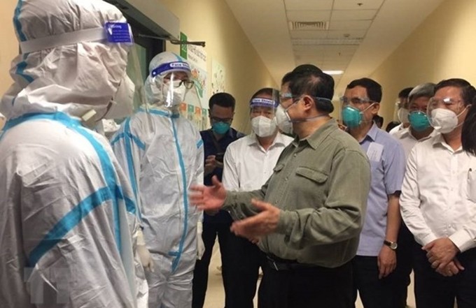 El primer ministro vietnamita, Pham Minh Chinh, inspecciona el control pandémico en Binh Duong. (Fotografía: VNA)