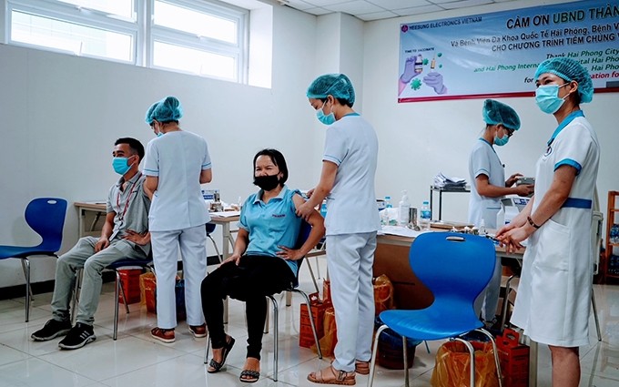 Los trabajadores del Parque Industrial de Trang Due, en el distrito de An Duong, reciben la vacuna contra el Covid-19.