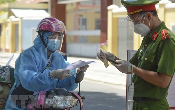 El policía revisa los documentos de un transportista en Ciudad Ho Chi Minh. (Fotografía: VNA)