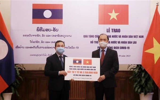 El viceministro de Relaciones Exteriores de Vietnam, Nguyen Quoc Dung (D), entrega la donación simbólica al embajador de Laos, Sengphet Houngboungnuang. (Fotografía: VNA)