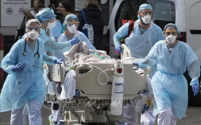 El personal médico transporta a un paciente infectado con Covid-19 a un hospital en la ciudad francesa de Mulhouse, el 22 de marzo de 2020. (Fotografía: AFP/VNA)