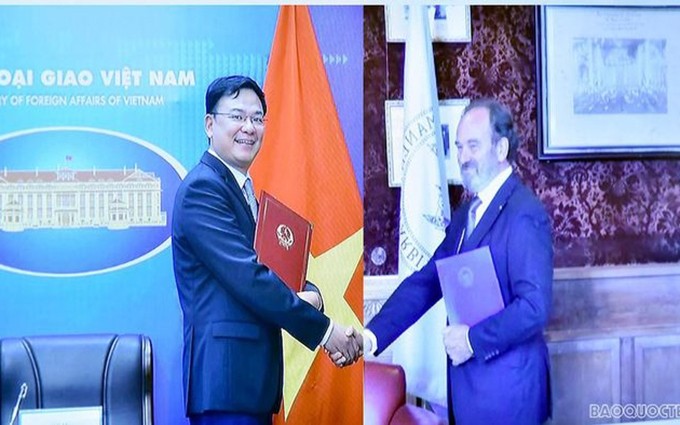 El viceministro de Relaciones Exteriores de Vietnam, Pham Quang Hieu y el vicesecretario de la CPA, firman el acuerdo de manera virtual. (Fotografía: baoquocte.vn)