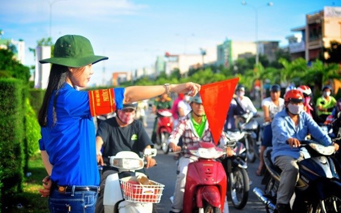 Jóvenes voluntarios participan en el mantenimiento del orden y la seguridad del tráfico. (Fotografía: thanhnien.vn)