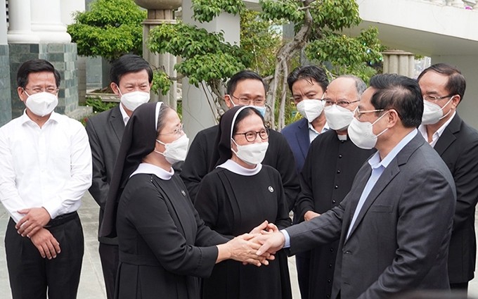 El primer ministro Pham Minh Chinh saluda y entrega regalos a fieles de la Parroquia de Long Huong en ocasión de la Navidad (Fotografía: Nhan Dan)