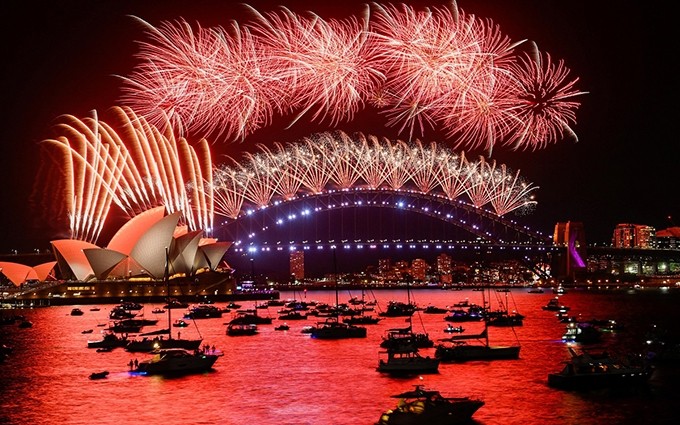 Los fuegos artificiales iluminan el puente de la bahía de Sídney, en Australia, en el primer momento del año nuevo 2022. (Foto: Reuters)