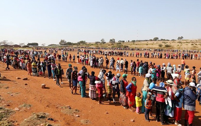 Personas hacen cola esperando su turno para recibir alimentos en Sudáfrica. (Fotografía: Reuters)