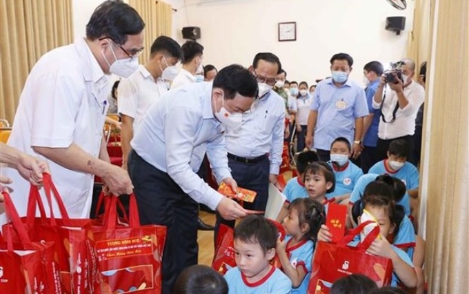 El presidente de la Asamblea Nacional de Vietnam, Vuong Dinh Hue, entrega regalos a niños discapacitados en el centro (Foto: VNA)