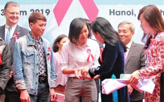 La ministra de Salud Pública de Vietnam, Nguyen Thi Kim Tien, entregó a los pacientes el medicamento antirretroviral contra el VIH obtenido con los fondos nacionales de seguro médico. 