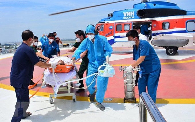 Trasladan a pacientes desde el helicóptero al Hospital Militar 175. (Fotografía: VNA)