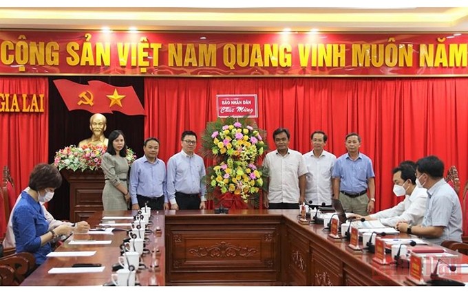 En nombre de la delegación, el compañero Le Quoc Minh entrega a ejecutivos de Gia Lai flores de felicitación por el 47 aniversario del Día de la Liberación de esa provincia. (Fotografía: Nhan Dan)