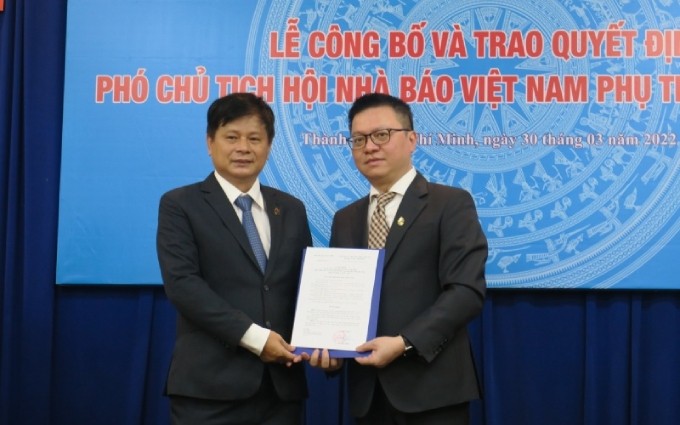 El miembro del Comité Central del Partido Comunista de Vietnam (PCV), jefe de redacción del periódico Nhan Dan, subjefe de la Comisión de Comunicación y Educación del Comité Central del PCV y presidente de la Asociación de Periodistas de Vietnam, Le Quoc Minh entrega la decisión a Tran Trong Dung.