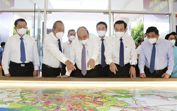 El presidente de Vietnam, Nguyen Xuan Phuc, revisa el mapa de planificación de los distritos de Hoc Mon y Cu Chi (Foto: VNA)