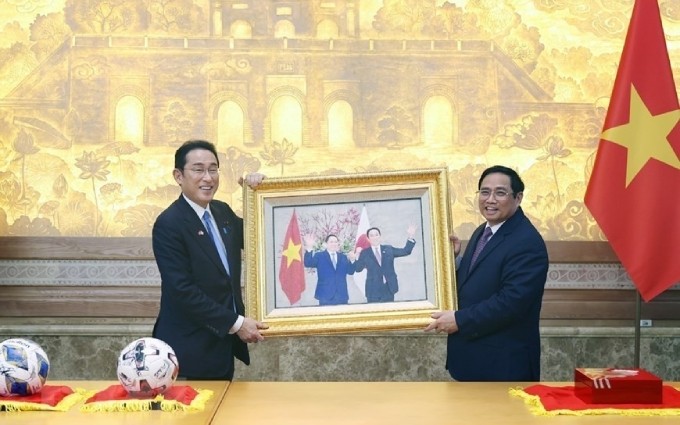 El primer ministro de Vietnam, Pham Minh Chinh entrega regalo a su homólogo japonés, Kishida Fumio. (Foto: VNA)