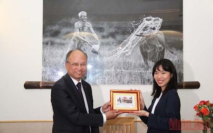 El embajador Dinh Toan Thang entrega a la comunidad vietnamita en Niza un sello con la imagen del Presidente Ho Chi Minh emitido por el Correo francés con motivo del centenario de su llegada al país europeo. (Fotografía: Nhan Dan)