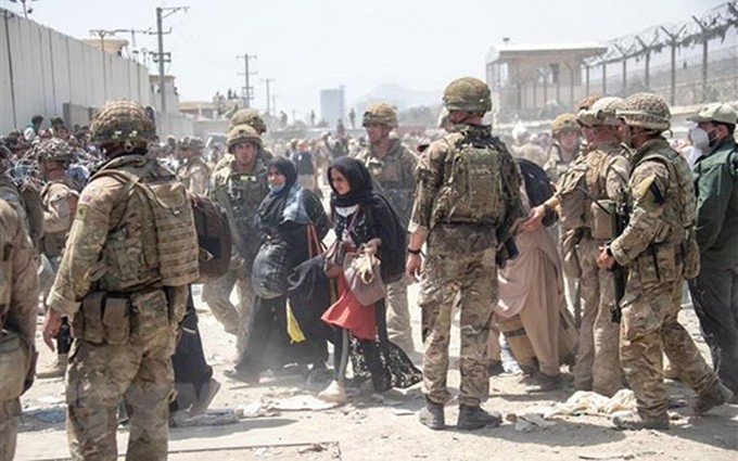 Soldados británicos y estadounidenses ayudan en la evacuación en la zona del aeropuerto de Kabul, en Afganistán. (Fotografía: AFP/VNA)