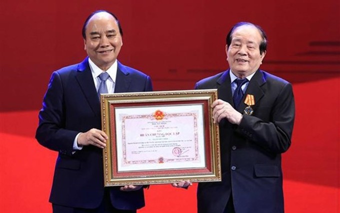 El presidente de Vietnam, Nguyen Xuan Phuc, entrega la Orden de Independencia de segunda clase al poeta Huu Thinh. (Foto: VNA)