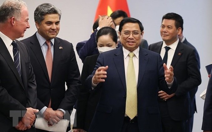 El primer ministro vietnamita, Pham Minh Chinh, y gerentes de organizaciones mundiales. (Fotografía: VNA)