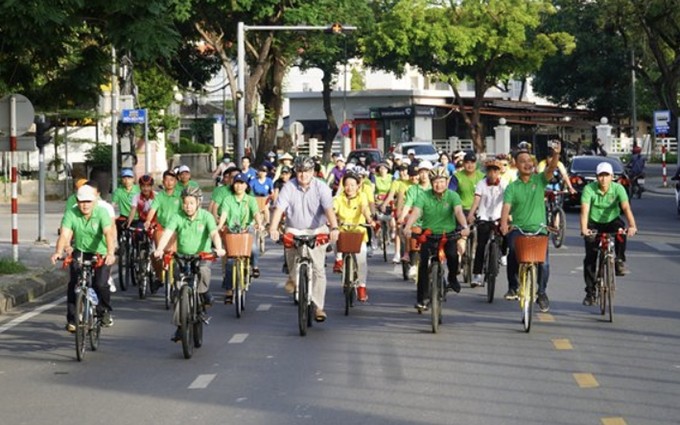 El embajador de Dinamarca en Vietnam, Kim Højlund Christensen, dirigentes y ciudadanos locales, hacen un recorrido en bicicleta para responder al evento.