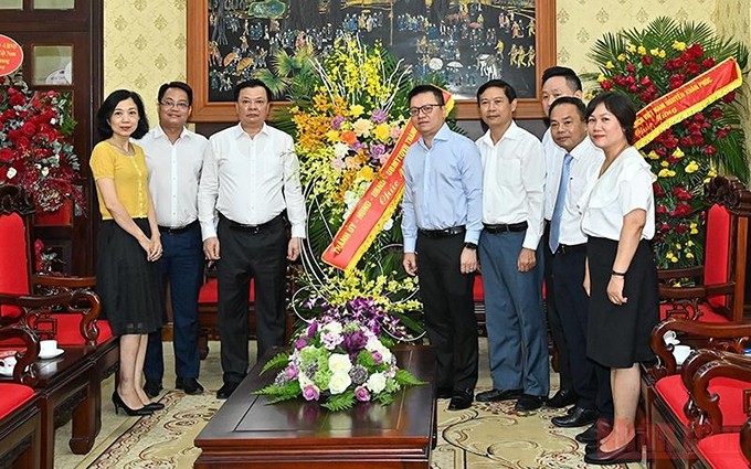 El secretario del Comité del Partido Comunista de Vietnam en Hanói, Dinh Tien Dung, entrega flores a ejecutivos de Nhan Dan con motivo del Día de la Prensa Revolucionaria. (Fotografía: Nhan Dan)