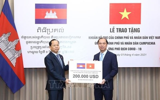 El viceministro de Relaciones Exteriores, Nguyen Quoc Dung, entrega apoyo financiero del Gobierno y el pueblo de Vietnam para apoyar a Camboya en la lucha contra la Covid-19. (Fotografía: VNA)