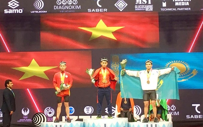 El pesista vietnamita K'Duong en el podio recibiendo la medalla de oro. (Fotografía: qdnd.vn)