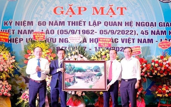 El segundo jefe de la Embajada de Laos en Vietnam, Chanthaphone Khammanichanh (segundo desde la izquierda) recibe recuerdo del Comité Popular de Bac Giang.
