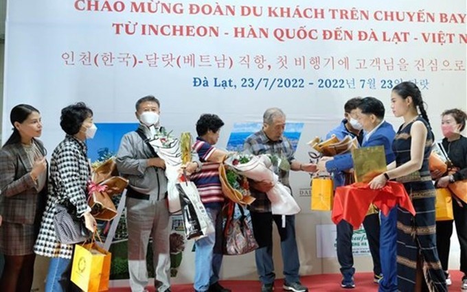 Representantes del Servicio de Cultura, Deportes y Turismo de la provincia de Lam Dong entregan flores a turistas de Corea del Sur. (Fotografía: VNA)