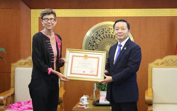 El ministro de Recursos Naturales y Medio Ambiente, Tran Hong Ha, entrega la medalla a la embajadora de Noruega, Grete Lochen. (Fotografía: VNA) 