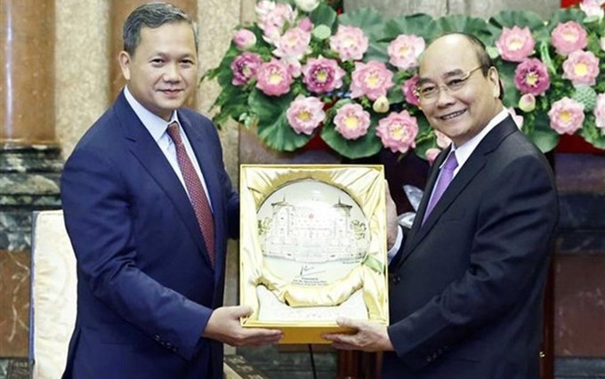 El presidente de Vietnam, Nguyen Xuan Phuc (derecha), obsequia un regalo a Hun Manet, miembro del Comité Permanente del Partido Popular y subcomandante en jefe y comandante del Ejército Real de Camboya. (Fotografía: VNA)