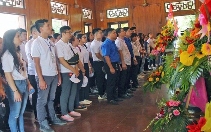 La delegación de más de 150 jóvenes expatriados vietnamitas ofrece inciensos y flores al Presidente Ho Chi Minh en su casa conmemorativa. (Fotografía: nhandan.com.vn)