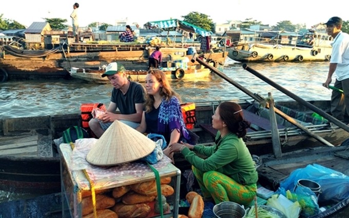 Los turistas visitan al mercado flotante de Cai Rang. 