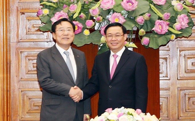 El viceprimer ministro de Vietnam, Vuong Dinh Hue (D) recibe al presidente de KBIZ, Kim Ki-mun.