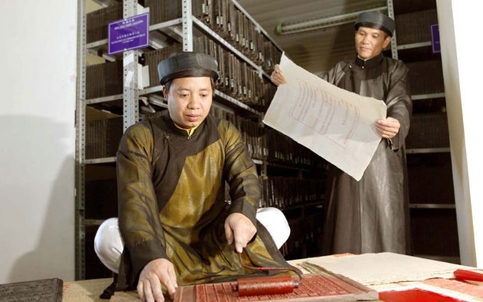 Artesanos presentan en la exposición la técnica de impresión de documentos en las planchas de madera. 