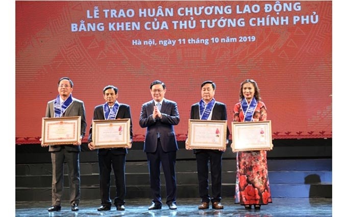 El viceprimer ministro, Vuong Dinh Hue entregó la Orden del Trabajo y el Certificado de Mérito a las empresas. (Fotografía: nhandan.com.vn)