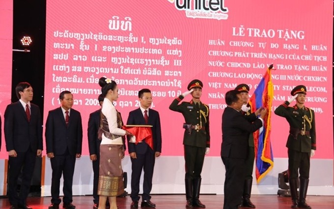Entrega de las Órdenes de Isala y Phatthana, del Gobierno de Laos, a la empresa Unitel. (Fotografía: Nhan Dan)
