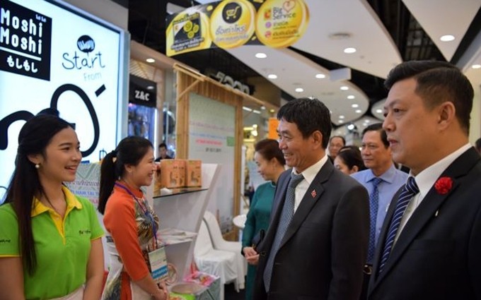 El embajador de Vietnam en Tailandia, Nguyen Hai Bang, y otros asistentes al evento visitan un stand de productos vietnamitas. (Fotografía: Nhan Dan)